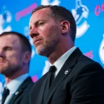 May 14, 2026; Vancouver, BC, Canada; Daniel Sedin listens to Ryan Johnson speak during a press conference where the Vancouver Canucks name new senior management staff. Henrik Sedin and his twin brother Daniel Sedin have been appointed as co-presidents of hockey operations and Ryan Johnson is now the new general manager of the club at Rogers Arena. :