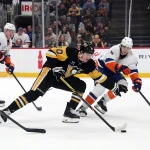 Confirmé : Kent Hughes a réalisé un coup d'éclat avec cet échange majeur 29 décembre 2024 ; Pittsburgh, Pennsylvanie, États-Unis ; l\'ailier gauche des Penguins de Pittsburgh, Drew O\'Connor (10), patine avec la rondelle face au défenseur des Islanders de New York, Noah Dobson (8), durant la première période à la PPG Paints Arena.