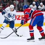 25 septembre 2025; Montréal, Québec, Canada; l'attaquant des Maple Leafs de Toronto, Easton Cowan (53), tire au but contre le centre des Canadiens de Montréal, Jared Davidson (49), durant la deuxième période au Centre Bell.
