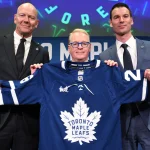 May 4, 2026; Toronto, Ontario, CANADA; Maple Leaf Sports and Entertainment CEO Keith Pelley holds a team jersey between Toronto Maple Leafs general manager John Chayka (right) and senior executive advisor Mats Sundin during an introductory news conference at Real Sports Bar and Grill.