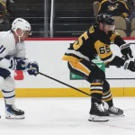 Nov 29, 2025; Pittsburgh, Pennsylvania, USA; Pittsburgh Penguins defenseman Erik Karlsson (65) moves the puck against pressure from Toronto Maple Leafs center Max Domi (11) during the second period at PPG Paints Arena.