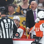 Apr 18, 2026; Pittsburgh, Pennsylvania, USA; Philadelphia Flyers head coach Rick Tocchet (right rear) reacts to linesman Devin Berg (87) against the Pittsburgh Penguins during the first period in game one of the first round of the 2026 Stanley Cup Playoffs at PPG Paints Arena.