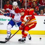 8 mars 2025; Calgary, Alberta, Canada; Matt Coronato (27), ailier droit des Flames de Calgary, et Arber Xhekaj (72), défenseur des Canadiens de Montréal, se disputent la rondelle durant la deuxième période au Scotiabank Saddledome.