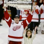 Steve Yzerman holds up the Stanley cup with his daughter Isabella after winning the cup for the third time in 2002.