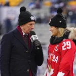 Mar 13, 2022; Hamilton, Ontario, CAN; Ron MacLean speaks to Marie-Philip Poulin Captain of the Canadian Women\'s hockey team as they are honored during the second intermission at the 2022 Heritage Classic ice hockey game at Tim Hortons Field. Mandatory Credit: John E. Sokolowski-USA TODAY Sports