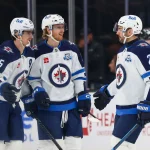 Apr 14, 2026; Salt Lake City, Utah, USA; Winnipeg Jets center Mark Scheifele (55) celebrates with left wing Kyle Connor (81) and defenseman Dylan DeMelo (2) after scoring a goal against the Utah Mammoth during the third period at Delta Center. Mandatory Credit: Rob Gray-Imagn Images