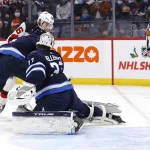 Dec 3, 2021; Winnipeg, Manitoba, CAN; New Jersey Devils center Jack Hughes (86) scores on Winnipeg Jets goaltender Connor Hellebuyck (37) in the first period at Canada Life Centre. Mandatory Credit: James Carey Lauder-USA TODAY Sports