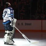 Mar 21, 2026; Pittsburgh, Pennsylvania, USA; Winnipeg Jets goaltender Connor Hellebuyck (37) stands for the national anthem against the Pittsburgh Penguins at PPG Paints Arena.