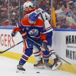 6 mars 2025; Edmonton, Alberta, Canada; L'attaquant des Oilers d'Edmonton, Adam Henrique (19), et le défenseur des Canadiens de Montréal, Arber Xhekaj (72), se disputent une rondelle libre le long de la bande durant la première période au Rogers Place.