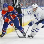 Jan 16, 2024; Edmonton, Alberta, CAN; Edmonton Oilers forward Zach Hyman (18) and Toronto Maple Leafs forward Calle Jarnkrok (19) Battle along the boards for a loose puck during the third period at Rogers Place