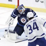 Auston Matthews is quietly bucking a growing trend around the NHL May 14, 2021; Winnipeg, Manitoba, CAN; Winnipeg Jets goaltender Connor Hellebuyck (37) stops a shot by Toronto Maple Leafs center Auston Matthews (34) in the third period at Bell MTS Place. Mandatory Credit: James Carey Lauder-USA TODAY Sports