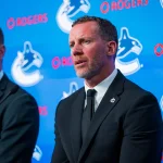 May 14, 2026; Vancouver, BC, Canada; Daniel Sedin listens to Ryan Johnson speak during a press conference where the Vancouver Canucks name new senior management staff. Henrik Sedin and his twin brother Daniel Sedin have been appointed as co-presidents of hockey operations and Ryan Johnson is now the new general manager of the club at Rogers Arena.