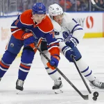 Mar 1, 2023; Edmonton, Alberta, CAN; Edmonton Oilers forward Ryan McLeod (71) and Toronto Maple Leafs forward Calle Jarnkrok (19) battle for a loose puck during the second period at Rogers Place.