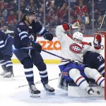 3 novembre 2022; Winnipeg, Manitoba, Canada; Nick Suzuki (14), centre des Canadiens de Montréal, tacle le gardien des Jets de Winnipeg, Connor Hellebuyck (37), après son but en première période au Canada Life Centre.