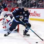 4 février 2026; Winnipeg (Manitoba, Canada); Cole Perfetti (91), centre des Jets de Winnipeg, contrôle la rondelle face au gardien des Canadiens de Montréal, Samuel Montembeault (35), en deuxième période au Centre Canada Life.