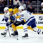 Mar 22, 2025; Nashville, Tennessee, USA; Toronto Maple Leafs defenseman Morgan Rielly (44) and Toronto Maple Leafs left wing Matthew Knies (23) stop an attack by Nashville Predators right wing Luke Evangelista (77) during the third period of the game at Bridgestone Arena