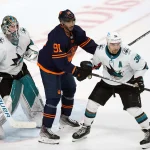 Feb 14, 2022; San Jose, California, USA; Edmonton Oilers left wing Evander Kane (91) sets up between San Jose Sharks goaltender James Reimer (47) and defenseman Mario Ferraro (38) during the third period at SAP Center at San Jose. Mandatory Credit: Darren Yamashita-USA TODAY Sports