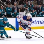 Apr 8, 2026; San Jose, California, USA; Edmonton Oilers center Connor McDavid (97) controls the puck while defended by San Jose Sharks right wing Collin Graf (51) during the first period at SAP Center at San Jose.