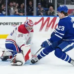 8 octobre 2025; Toronto, Ontario, Canada; L'ailier gauche des Maple Leafs de Toronto, Matthew Knies (23), se bat devant le gardien des Canadiens de Montréal, Sam Montembeault (35), durant la troisième période à la Scotiabank Arena.