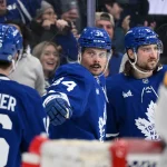 Dec 4, 2024; Toronto, Ontario, CAN; Toronto Maple Leafs forward Auston Matthews (34) celebrates with forward Mitch Marner (16) and defenseman Chris Tanev (8) after scoring a goal against the Nashville Predators at Scotiabank Arena.