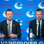 May 14, 2026; Vancouver, BC, Canada; Henrik Sedin listens to Daniel Sedin speak during a press conference where the Vancouver Canucks name new senior management staff. Henrik Sedin and his twin brother Daniel Sedin have been appointed as co-presidents of hockey operations and Ryan Johnson is now the new general manager of the club at Rogers Arena.