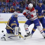 26 novembre 2021 ; Buffalo, New York, États-Unis ; Christian Dvorak (28), centre des Canadiens de Montréal, tente de dévier un tir dirigé vers Dustin Tokarski (31), gardien des Sabres de Buffalo, durant la première période au KeyBank Center.