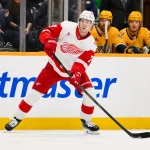 Mar 2, 2026; Nashville, Tennessee, USA; Detroit Red Wings defenseman Simon Edvinsson (77) passes the puck against the Nashville Predators during the first period at Bridgestone Arena.