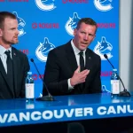 May 14, 2026; Vancouver, BC, Canada; Daniel Sedin listens to Ryan Johnson speak during a press conference where the Vancouver Canucks name new senior management staff. Henrik Sedin and his twin brother Daniel Sedin have been appointed as co-presidents of hockey operations and Ryan Johnson is now the new general manager of the club at Rogers Arena. :