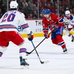 19 janvier 2025 ; Montréal, Québec, Canada ; le joueur de centre des Canadiens de Montréal Nick Suzuki (14) dispute la rondelle à l'ailier gauche des Rangers de New York Chris Kreider (20) durant la prolongation au Centre Bell.