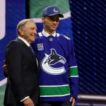 Jun 26, 2026; Buffalo, New York, USA; Adam Novotny reacts beside NHL commissioner Gary Bettman after being selected with the twenty fourth pick in the first round of the 2026 NHL Draft by the Vancouver Canucks at KeyBank Center.