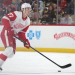 Mar 31, 2026; Pittsburgh, Pennsylvania, USA; Detroit Red Wings defenseman Simon Edvinsson (77) moves the puck against the Pittsburgh Penguins during the second period at PPG Paints Arena.