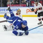 Dec 27, 2025; Toronto, Ontario, CAN; Toronto Maple Leafs forward Matthew Knies (23) falls to the ice after scoring on Ottawa Senators goaltender Leevi Merilainen (1) during the third period at Scotiabank Arena.