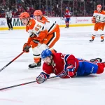 15 mars 2026; Montréal, Québec, Canada; Josh Anderson (17), ailier droit des Canadiens de Montréal, contrôle la rondelle après une chute sur la glace face à Beckett Sennecke (45), ailier droit des Ducks d'Anaheim, durant la troisième période au Centre Bell.