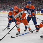 Apr 20, 2026; Edmonton, Alberta, CAN; Edmonton Oilers center Matt Savoie (22) with center Connor McDavid (97) attempt to stop Anaheim Ducks right winger Troy Terry (19) in game one of the first round of the 2026 Stanley Cup Playoffs during the second period at Rogers Place.
