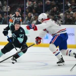 28 octobre 2025 ; Seattle, Washington, États-Unis ; le joueur de centre du Kraken de Seattle Berkly Catton (77) manie la palet sous la pression du joueur de centre des Canadiens de Montréal Alex Newhook (15) durant la troisième période à la Climate Pledge Arena.