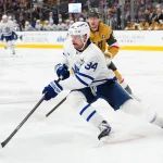 Jan 15, 2026; Las Vegas, Nevada, USA; Toronto Maple Leafs center Auston Matthews (34) skates ahead of Vegas Golden Knights center Jack Eichel (9) during the third period at T-Mobile Arena.