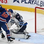Mar 20, 2025; Edmonton, Alberta, CAN; Edmonton Oilers left winger Zach Hyman (18) goes for a shot on Winnipeg Jets goalie Connor Hellebuyck (37) during the third period at Rogers Place.