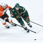 Mar 12, 2026; Saint Paul, Minnesota, USA; Minnesota Wild defenseman Quinn Hughes (43) and Philadelphia Flyers left wing Noah Cates (27) compete for the puck during the overtime at Grand Casino Arena.