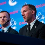 May 14, 2026; Vancouver, BC, Canada; Daniel Sedin listens to Ryan Johnson speak during a press conference where the Vancouver Canucks name new senior management staff. Henrik Sedin and his twin brother Daniel Sedin have been appointed as co-presidents of hockey operations and Ryan Johnson is now the new general manager of the club at Rogers Arena. :