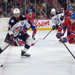 Mar 26, 2026; Montreal, Quebec, CAN; Columbus Blue Jackets forward Kirill Marchenko (86) plays the puck and Montreal Canadiens defenseman Kaiden Guhle (21) defends during the third period at the Bell Centre.