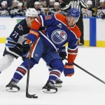 Sep 19, 2026; Edmonton, Alberta, CAN; Edmonton Oilers forward Alex Formenton (26) protects the puck from Winnipeg Jets defensemen Tyrel Bauer (77) during the third period at Rogers Place.