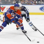 Sep 19, 2026; Edmonton, Alberta, CAN; Edmonton Oilers forward Connor McDavid (97) protects the puck from Winnipeg Jets defensemen Jack St. Ivany (6) during the first period at Rogers Place.