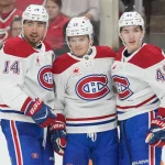 29 mars 2026 ; Raleigh, Caroline du Nord, États-Unis ; Le centre des Canadiens de Montréal, Nick Suzuki (14), est félicité par le défenseur Lane Hutson (48) et l\'ailier droit Cole Caufield (13) après avoir marqué un but contre les Hurricanes de la Caroline au cours de la deuxième période au Lenovo Center.