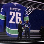Jun 26, 2026; Buffalo, New York, USA; Adam Novotny reacts beside NHL commissioner Gary Bettman after being selected with the twenty fourth pick in the first round of the 2026 NHL Draft by the Vancouver Canucks at KeyBank Center.