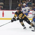 Sep 21, 2026; Pittsburgh, Pennsylvania, USA; Pittsburgh Penguins forward Andrei Kuzmenko (10) moves the puck against Buffalo Sabres defenseman Dennis Gilbert (44) during the first period at PPG Paints Arena.