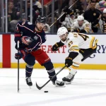 Apr 12, 2026; Columbus, Ohio, USA; Columbus Blue Jackets center Adam Fantilli (19) takes the puck away from Boston Bruins center Mark Kastelic (47) during the first period at Nationwide Arena.