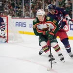 28 octobre 2025 ; Saint Paul, Minnesota, États-Unis ; l\'ailier gauche du Wild du Minnesota, Kirill Kaprizov (97), progresse avec le palet tout en étant gêné par la crosse du centre des Jets de Winnipeg, Mark Scheifele (55), lors de la prolongation à la Grand Casino Arena.