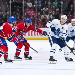 25 septembre 2025; Montréal, Québec, Canada; L'attaquant des Maple Leafs de Toronto, Steven Lorentz (18), joue la rondelle contre l'ailier droit des Canadiens de Montréal, Patrik Laine (92), et le centre Kirby Dach (77), durant la deuxième période au Centre Bell.