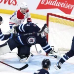 Dec 14, 2024; Winnipeg, Manitoba, CAN; Winnipeg Jets goaltender Connor Hellebuyck (37) stretches to make a glove save in the third period against the Montreal Canadiens at Canada Life Centre.