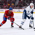 3 octobre 2022; Montréal, Québec, Canada; le défenseur des Maple Leafs de Toronto, Justin Holl (3), joue la rondelle contre l'ailier gauche des Canadiens de Montréal, Jonathan Drouin (27), durant la deuxième période au Centre Bell.